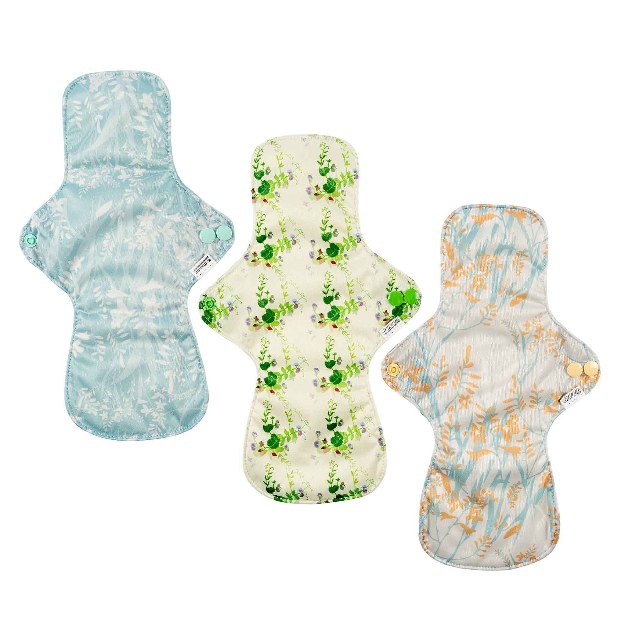 Three EcoKinly floral-patterned period pads on a white background