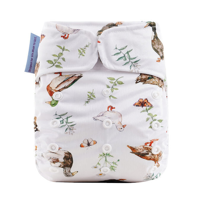 Patterned diaper cover with ducks and plants on a white background