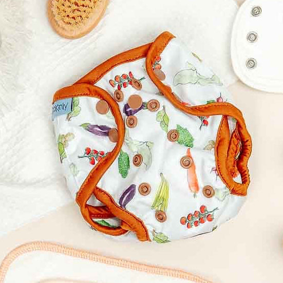 Baby items including bibs, toys, and clothing on a light surface