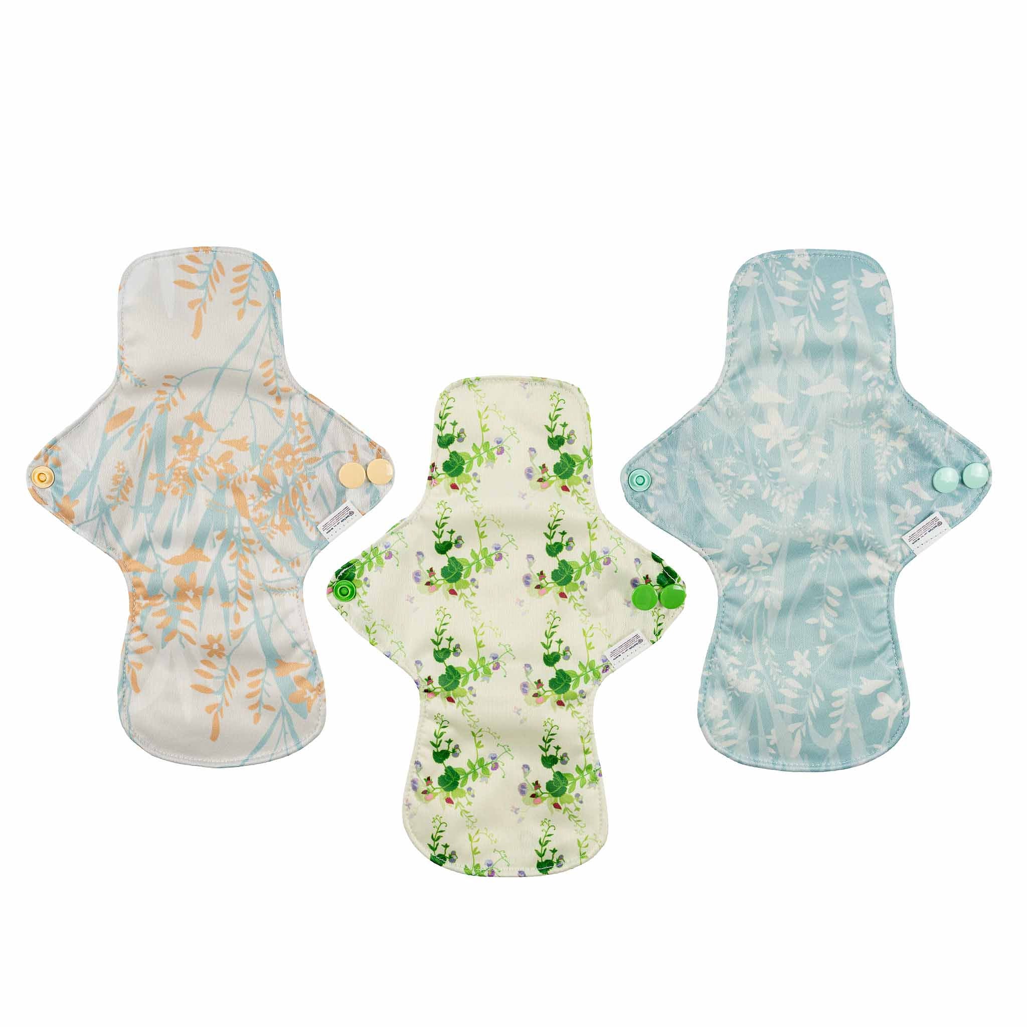 Three floral-patterned sanitary pads on a white background