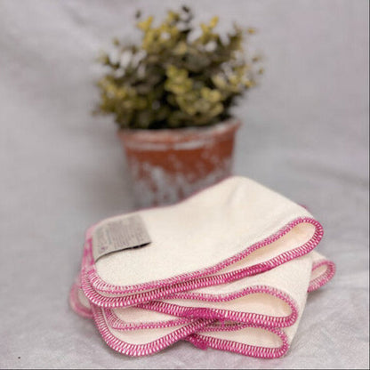 Stack of reusable cloth nappy inserts with red edge stitching 