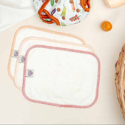 Baby items including bibs, toys, and clothing on a light surface