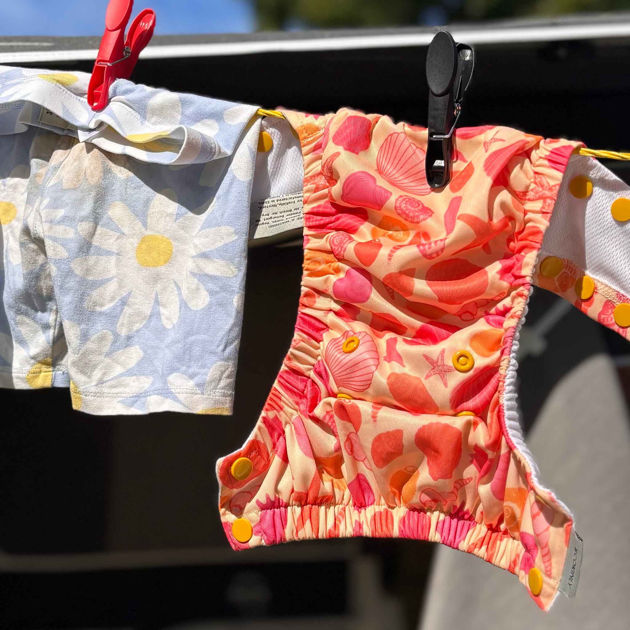 EcoKinly Splash & Dash Reusable Swim Nappy with Beach Treasures Pattern on clothes line 
